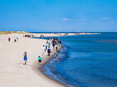 SKAGEN, DENMARK - 20 MAYIS 2023: mükemmel bir yaz günü plajda - büyük bir grup insan doğanın güzelliğinin ve dinginliğinin tadını çıkarıyor, sonsuz gökyüzü ile engin mavi okyanus suları buluşuyor.