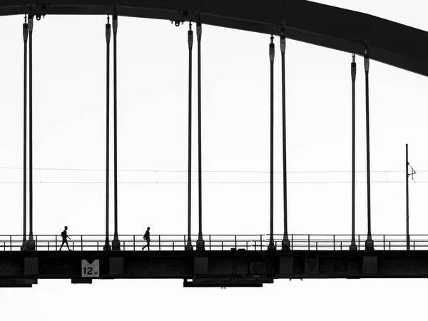 Σιλουέτα Ανθρώπων Που Διασχίζουν Μια Γέφυρα — Φωτογραφία Αρχείου