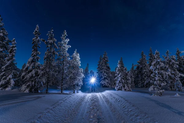 stock image Man with backpack and headlamp standing under starry sky