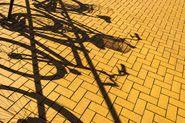 停在有影子的街上的自行车 — 图库照片