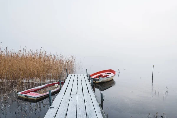 Barche Molo Ghiacciato Nel Lago Nebbioso Foto Stock