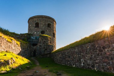Yeşillik ve antik taş duvarları olan ortaçağ kalesi.