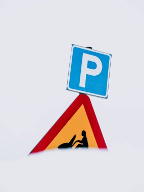 Swedish Road Sign Indicating Parking Place and Snowmobile Crossing Against a Snowy Background clipart