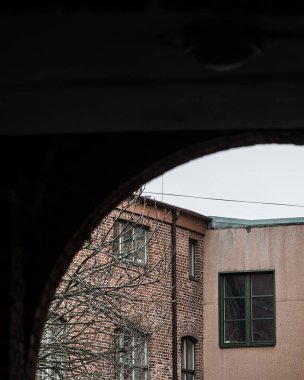 İsveç 'in Göteborg kentindeki eski bir sanayi binasını gösteren bir kemer manzarası. Binaların mimarisi gökyüzüne karşı kemer yolundan görülebilir..