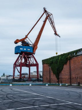 Vinç, tarihi tuğla binalarla çevriliyken yükleme ve boşaltmayı kolaylaştırmak için hazırlanan Göteborg limanının üzerinde beliriyor..