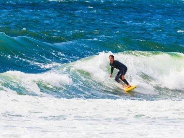 Bir sörfçü ustalıkla Molle, İsveç kıyılarında dalgalara biner. Adrenalin ve okyanus enerjisiyle dolu güneşli bir günün tadını çıkarır..