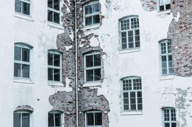 Terk edilmiş sanatoryum, beyaz boyalı ve kırık camlı, yıkık dökük tuğla duvarları ortaya çıkarıyor, zamanın geçişini gösteriyor ve rahatsız edici derecede güzel bir şekilde ihmal ediliyor..