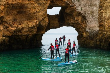 Bir grup, eşsiz kaya oluşumları ve sakin turkuaz sularla çevrili Ponta da Piedade, Algarve, Portekiz 'de kürek çekmeyi seviyor. Macera yerel doğayı gözler önüne seriyor..