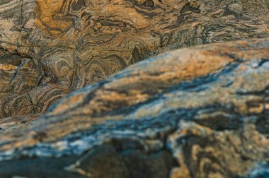 Sıcak ışık İsveç 'in engebeli uçurumlarına altın gibi bir parıltı saçar. Güneş batmaya başladığında kayalık yüzeylerdeki karmaşık dokuları ortaya çıkarır. Kıyı manzarasının güzelliğini vurgular..