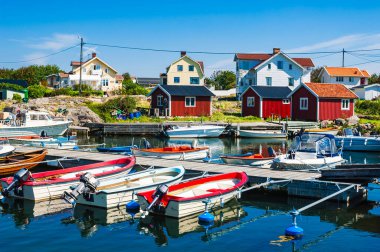 Parlak renkli tekneler, açık mavi gökyüzünün altındaki büyüleyici binalarla çevrili Vrango adasındaki rıhtımda, sakin bir yaz atmosferi sergiliyorlar..