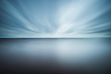 A tranquil seascape captures the serenity of twilight over calm waters in Sweden. Gentle blues and grays create a peaceful atmosphere as clouds drift slowly overhead. clipart