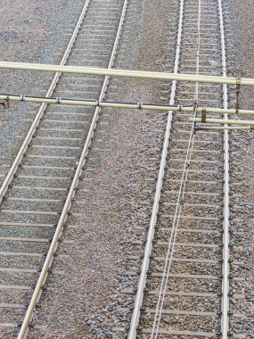 Göteborg 'da demiryolu iskeleti boyunca uzanıyor, parlak mavi gökyüzünün altında çakıllı bir yatak ve üstten kablolar ortaya çıkıyor..