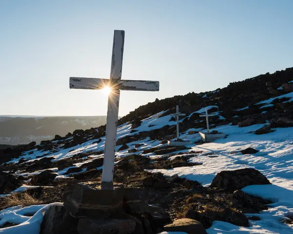 Gün batımında Grönland 'ın sakin bir kilisesindeki haçların arasından ılık bir parıltı yayarken kar manzarayı kaplıyor. Sahne, doğal güzelliğin ortasında huzur ve tefekküre yol açar..