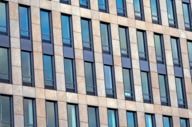 Güneşli bir günde Amsterdam 'da birçok penceresi olan bir bina. Otel, ofis merkezi ya da pansiyon. Kalacak yer. Cam cepheler. Hollanda 'nın mimarisi, Hollanda' nın. Şehircilik. Büyük şehir. Turizm ve seyahat.