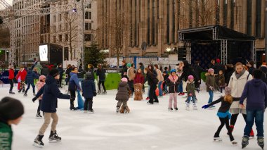 İnsanlar buz pateni pistinde eğleniyor, kadınlar, erkekler ve çocuklar. Noel pazarında buz pateni pistinde. DÜZSELDORF, ALMANA, 26 ARALIK 2022. Yüksek kalite fotoğraf