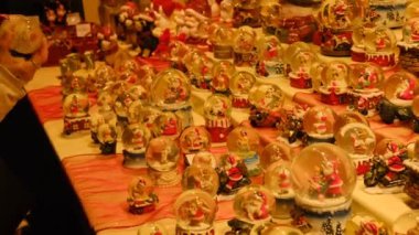Bir sürü dekoratif kar küresi ya da Noel Baba 'nın içinde olduğu Noel baloları. Noel ve Yeni Yıl dekoru Noel pazarının tezgahındaki ev için. Yüksek kalite 4k görüntü