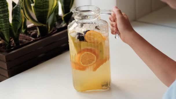 테이블에 오렌지 얼음으로 주전자에 홈메이드 레모네이드 만들기 고품질 Fullhd — 비디오