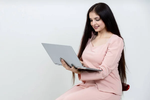 Indian latin woman using laptop and looking towards the laptop on isolated woman