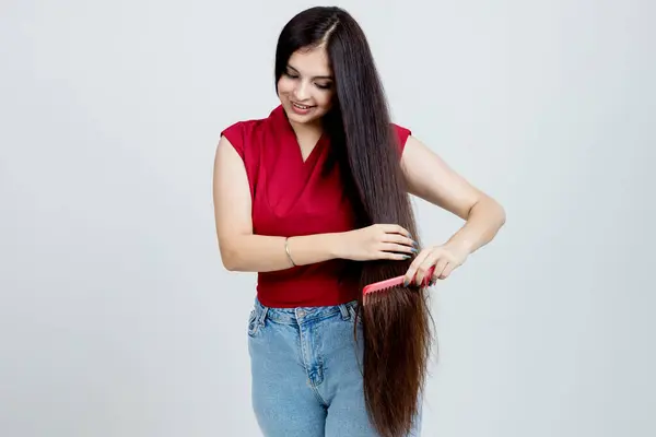 Indian Latin Girl Doing hair Brush Studio shot, Beauty and hair care concept
