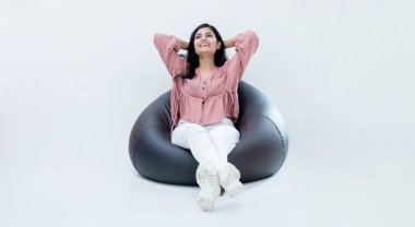 Hintli Latin kadın fasulye çuvalında oturuyor, rahatlıyor ve diğer tarafa bakıyor.