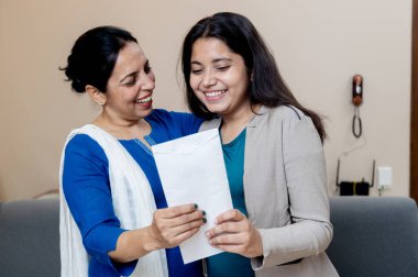 Hintli anne, kızı hayallerindeki işi bulduğu için mutlu. Ya da üniversiteye kabul edildiği için mutlu. Anne, kızının sıkı çalışmasından memnun.