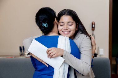 Anne kızına başarılı bir kariyer geleceği için sarıl, Hintli anne kızı hayallerindeki işi ya da koleje kabul edildiği için mutlu anne kızı için çok çalışıyor.