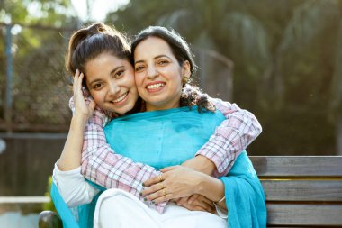 Annesine, annesine ve kızına sarılan mutlu Hintli kızın portresi