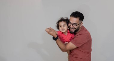 Hintli baba ve küçük çocuk birlikte eğleniyorlar, baba ve oğul birlikte oynuyorlar.