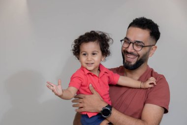 Hintli baba ve küçük çocuk birlikte eğleniyorlar, baba ve oğul birlikte oynuyorlar.