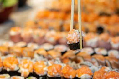 Somonlu çubuk ve arka planda Japon yemeği..