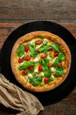 Buffalo Mozzarella Pizza. Domates soslu Napoli pizzası, mozzarella peyniri, pesto sosu, roka ve vişneli domates.