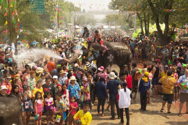 AYUTTHAYA , THAILAND - APRIL13, 2018: Elephants are using their trunks to spray water for Thai people and foreign tourists having fun. During the Songkran Festival, the traditional Thai New Year Day . At the Naresuan road in Ayutthaya city ,Thailand.
