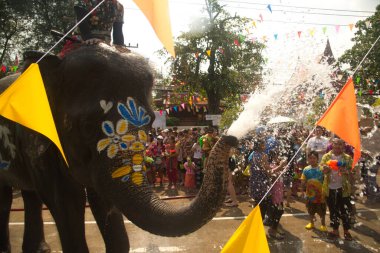 AYUTTHAYA , THAILAND - APRIL13, 2018: Elephants are using their trunks to spray water for Thai people and foreign tourists having fun. During the Songkran Festival, the traditional Thai New Year. At the road in Ayutthaya province, Middle of Thailand.