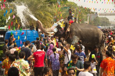 AYUTTHAYA , THAILAND - APRIL13, 2018: Elephants are using their trunks to spray water for Thai people and foreign tourists having fun. During the Songkran Festival, the traditional Thai New Year Day . At the Naresuan road in Ayutthaya city ,Thailand.
