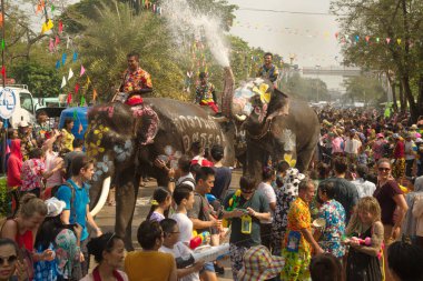 AYUTTHAYA , THAILAND - APRIL13, 2018: Elephants are using their trunks to spray water for Thai people and foreign tourists having fun. During the Songkran Festival, the traditional Thai New Year Day . At the Naresuan road in Ayutthaya city ,Thailand.