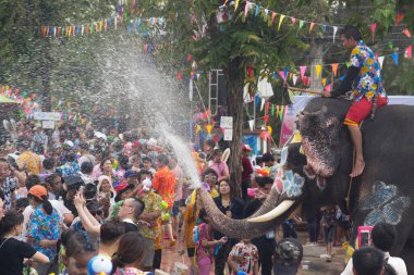 AYUTTHAYA , THAILAND - APRIL13, 2018: Elephants are using their trunks to spray water for Thai people and foreign tourists having fun. During the Songkran Festival, the traditional Thai New Year Day . At the Naresuan road in Ayutthaya city ,Thailand.
