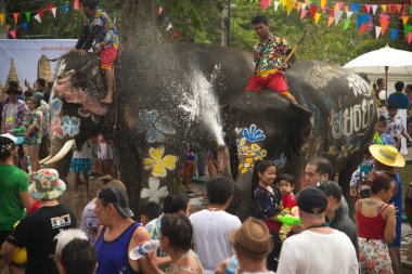AYUTTHAYA , THAILAND - APRIL13, 2018: Elephants are using their trunks to spray water for Thai people and foreign tourists having fun. During the Songkran Festival, the traditional Thai New Year Day . At the Naresuan road in Ayutthaya city ,Thailand.