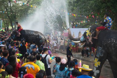 AYUTTHAYA , THAILAND - APRIL13, 2018: Elephants are using their trunks to spray water for Thai people and foreign tourists having fun. During the Songkran Festival, the traditional Thai New Year Day . At the Naresuan road in Ayutthaya city ,Thailand.