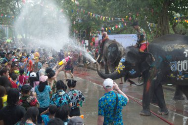 AYUTTHAYA , THAILAND - APRIL13, 2018: Elephants are using their trunks to spray water for Thai people and foreign tourists having fun. During the Songkran Festival, the traditional Thai New Year Day . At the Naresuan road in Ayutthaya city ,Thailand.