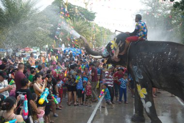 AYUTTHAYA , THAILAND - APRIL13, 2018: Elephants are using their trunks to spray water for Thai people and foreign tourists having fun. During the Songkran Festival, the traditional Thai New Year Day . At the Naresuan road in Ayutthaya city ,Thailand.