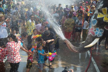 AYUTTHAYA , THAILAND - APRIL13, 2018: Elephants are using their trunks to spray water for Thai people and foreign tourists having fun. During the Songkran Festival, the traditional Thai New Year Day . At the Naresuan road in Ayutthaya city ,Thailand.