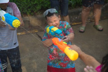 AYUTTHAYA,THAILAND - APRIL13, 2018 : Unidentified little boy play and enjoy water spraying with plastic gun. Join in on the Songkran Festival , the traditional New Year celebration from April 13 to 15 in Ayutthaya Province , Middle of Thailand.