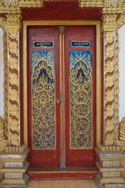 Traditional Thai art pattern made of wood decorated at the Thai Church door at Wat Somdet, a historic site in Amphoe Sangkhlaburi , Kanchanaburi Province , Middle of Thailand. 
