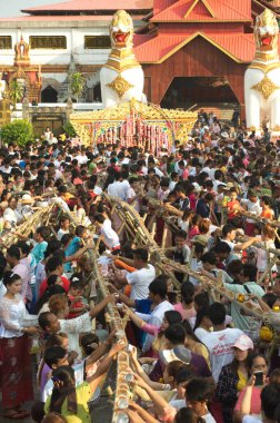 KANCHANABURI ,THAILAND - APRIL 16, 2016 : Large group of unidentified Thai-Mon minority pour water for monks by pouring it into a bamboo trough at Wat Wangwiwegaram , Amphoe Sangkhlaburi , Kanchanaburi Province in Songkran festival of Thailand. 