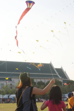 BANGKOK, THAILAND - 20 Nisan 2014: Sanam Luang 'da eğlenmek için tatilde uçurtma oynayan kimliği belirsiz bir aile. Tayland 'ın Bangkok kentindeki Rattanakosin şehrinin 232. yılındaki Tayland panayırında..