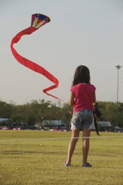 BANGKOK, THAILAND - 20 Nisan 2014: Sanam Luang 'da eğlenmek için tatilde uçurtma oynayan kimliği belirsiz bir aile. Tayland 'ın Bangkok kentindeki Rattanakosin şehrinin 232. yılındaki Tayland panayırında..