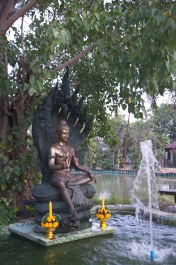 Wat Pa Pathom Chai 'deki bir gölet ve çeşmede bulunan melek heykelleri ya da koruyucular. Tayland 'ın Nakhon Pathom Eyaleti' nde yer alıyor..