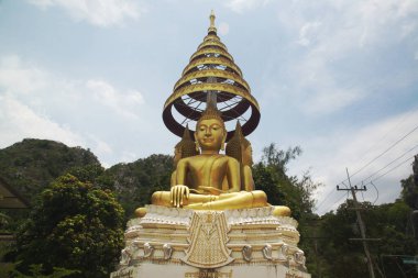 Dört yönlü Altın Oturan Buda resmi Wat Thamkrabok tapınak alanında gizlidir. Tayland 'ın ortasındaki Saraburi eyaletinde yer almaktadır..