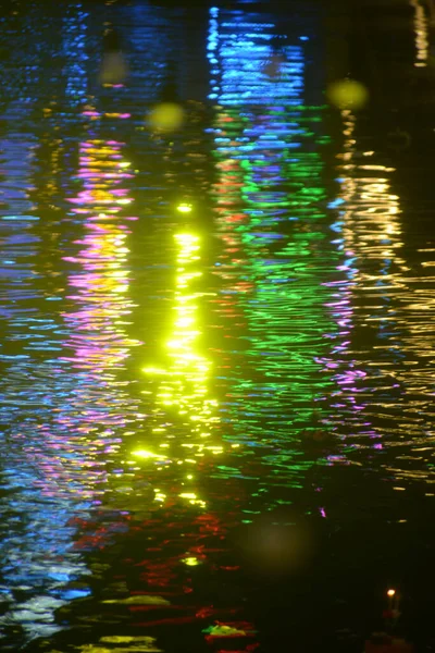 Texture and background image of the color lights reflection on the water surface.