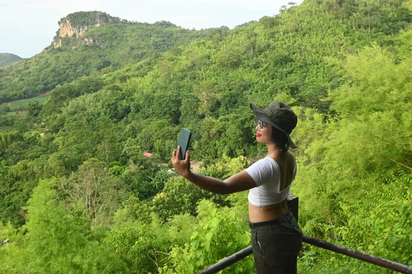 Güzel Asyalı turist kadın cep telefonuyla selfie çekiyor..